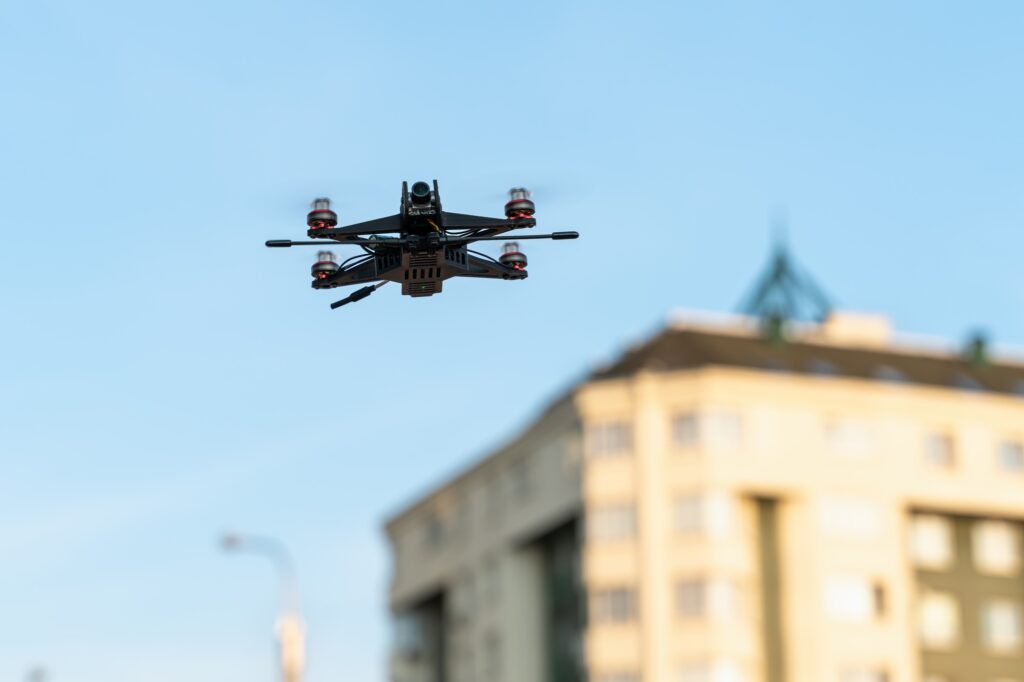 A small sports drone reconnaissance flies in the air among the buildings in the city